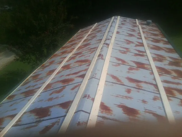 Rusted metal roof panels with new wood purlins before replacement — Storm Damage Roof Repair in Saint Stephens Church by Roofing Brothers