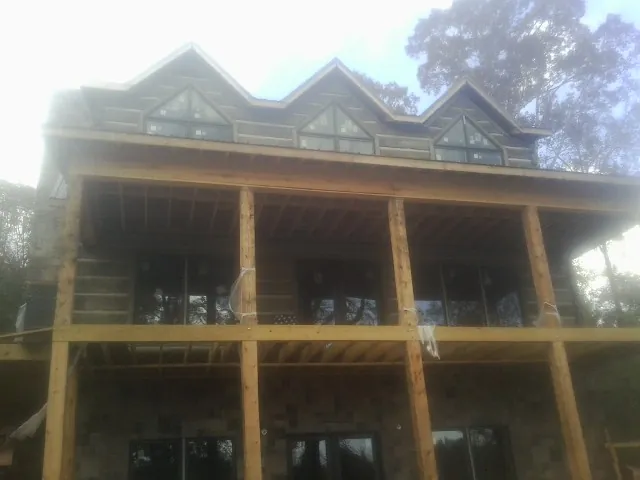 Dormers and porch framing on a large log home under construction — Roof Coating work by our crew in Saint Stephens Church
