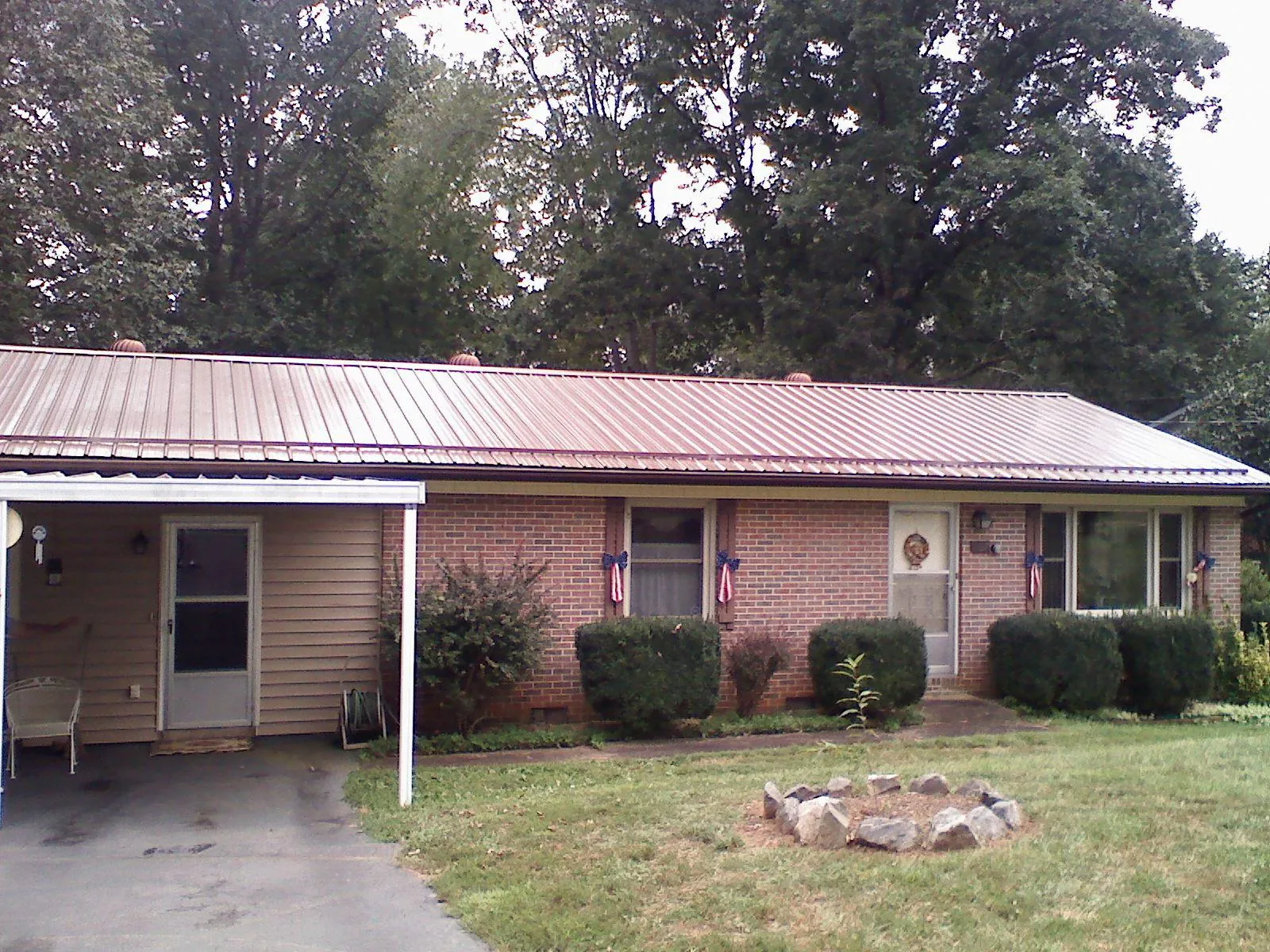 Bronze metal roof and carport on a brick ranch home — Roof Repair work by our crew in Saint Stephens Church